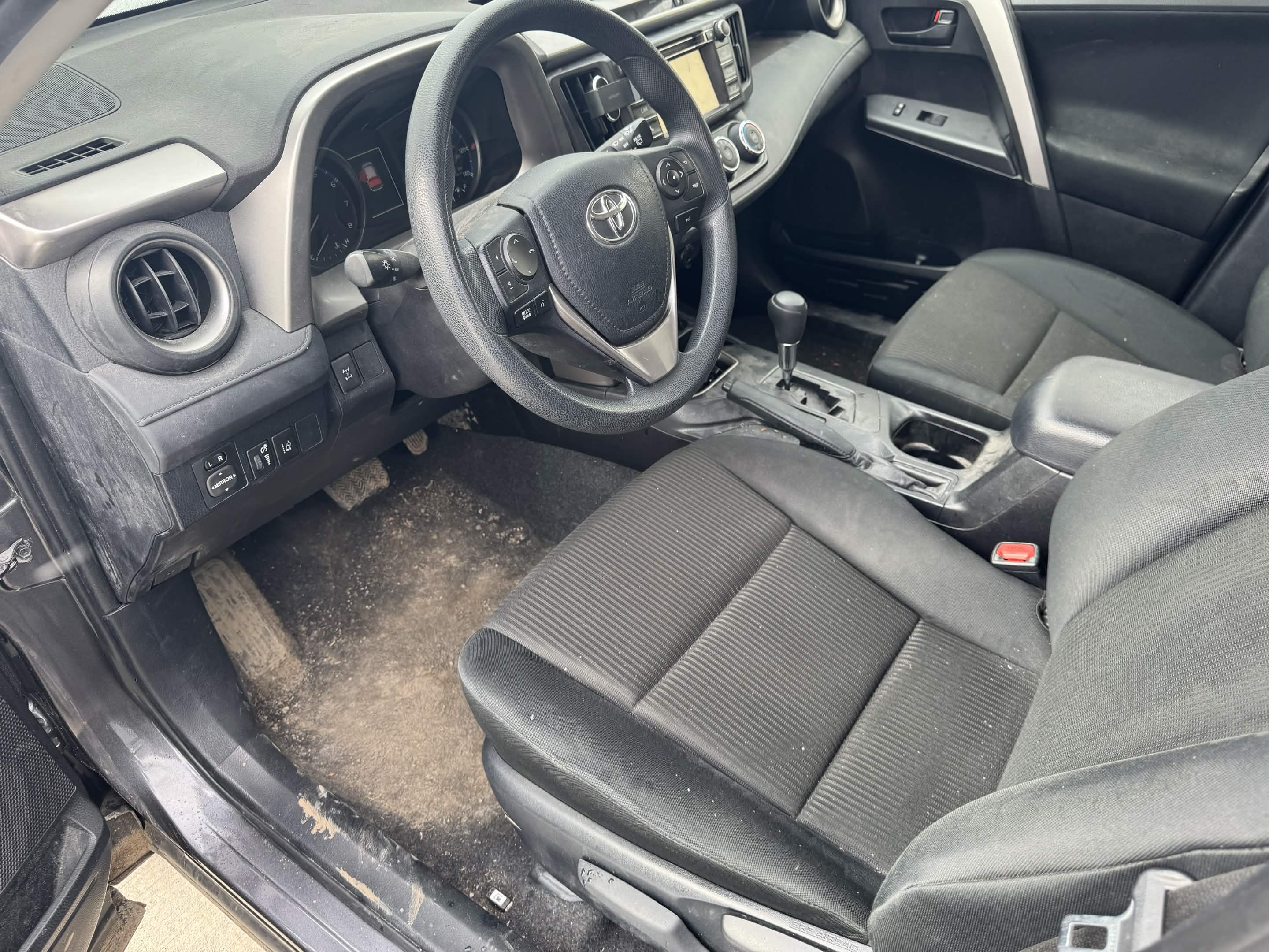 Before Cleveland interior car detailing showing dusty dashboard, dirty carpet, and debris on the floor