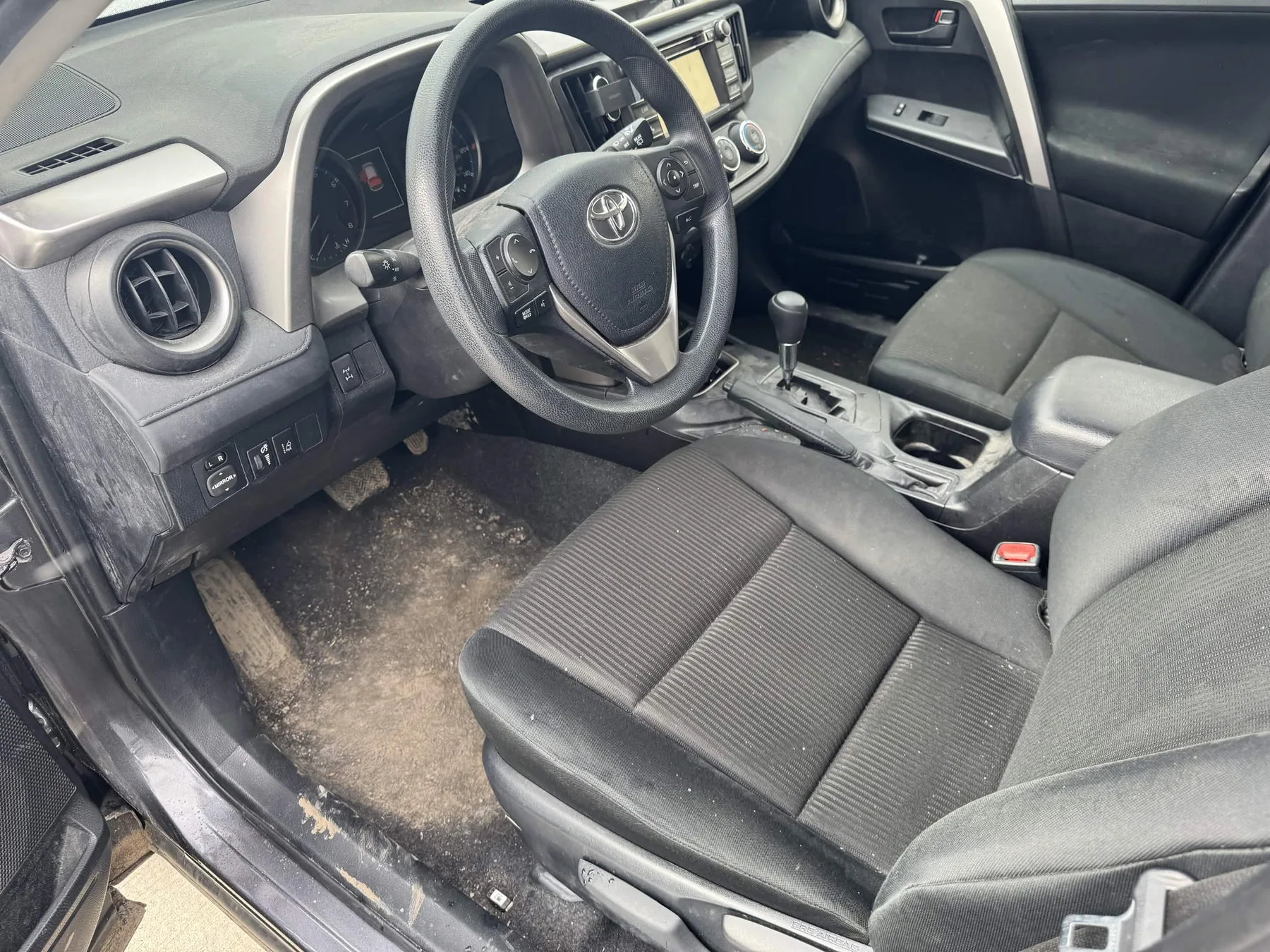 Before North Olmsted interior car detailing showing dusty dashboard, dirty carpet, and debris on the floor